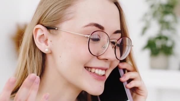 Retrato de caucasiano jovem loira millennial menina falando no telefone celular conversando conversa remotamente no dispositivo sem fio gadget, close-up rosto feminino alegre mulher usa smartphone para se comunicar — Vídeo de Stock