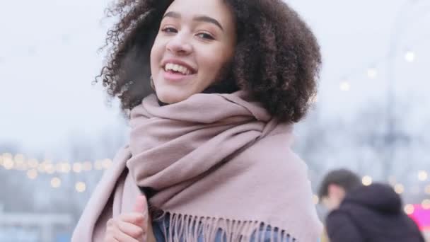 Portret donker gevilde vrouw krullend afro amerikaans meisje model draagt stijlvolle buitenkleding geniet roze mooie warme sjaal lacht kijken naar camera staat buiten, vriendin voelt geluk poseren in de stad — Stockvideo