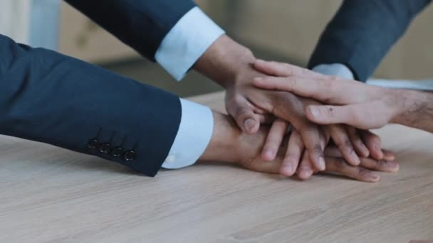 Brazos de primer plano de la empresa multinacional de grupo multirracial de diferentes etnias personas colegas hombres de negocios gerentes trabajadores de oficina apilan las manos ponen las palmas juntas en la mesa de madera, equipo de apoyo de confianza — Vídeos de Stock