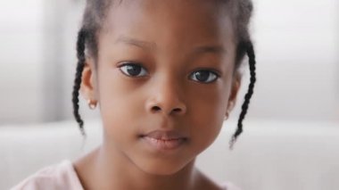 Yakından bakınca sevimli Afrikalı etnik çocuk kameraya bakıyor, yalnız bir zenci kızın portresi afro amerikalı küçük bir bebek anaokulu kızı üzgün bir ifadeyle evine bakıyor