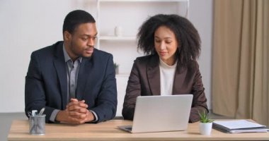 Kadın avukat, ofisteki Afro-Amerikalı iş adamına danışmanlık yapıyor. Meslektaşlar, masada oturup dizüstü bilgisayarını incelemeyi tartışıyor. Kıvırcık saçlı kız, bilgisayarla patronuna rapor sunuyor.