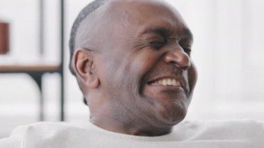 Olgun bir Afrikalı portre, siyah, yüzü buruşuk, yüzü buruşuk, duygusal, yaşlı, afro etnik bir baba. Kameraya bakıp gülüyor ve iyi niyet göstergesi gösteriyor.