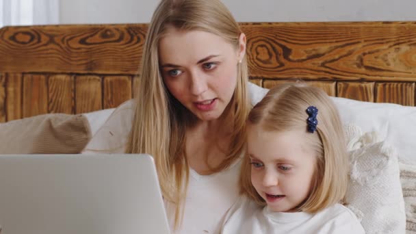 Ritratto di giovane madre madre madre adulta con bambina bambina guarda lo schermo del computer portatile parlare in web camera facendo videochiamata online conferenza, close up donna insegna uso del bambino servizio di app per computer — Video Stock