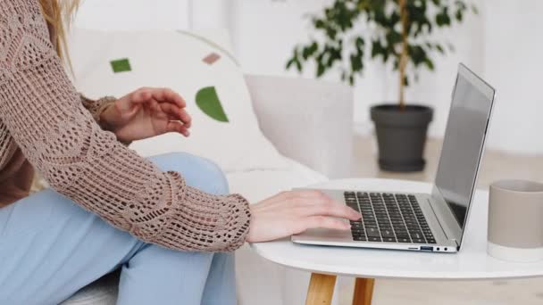 Schnittwunden unkenntlich Frau tippt auf Laptop sitzt zu Hause auf der Couch Werke online halten Bauch mit Händen fühlt Schmerzen im Bauch Schmerzen leidet unter Krämpfen schmerzhafte Menstruation Vergiftung Symptom — Stockvideo