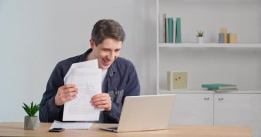 Mutlu Kafkasyalı bin yıllık iş adamı online görüntülü konuşma yapan, memnun olmuş bir adam. Ev ofisinde oturmuş, laptop web kamerasına konuşuyor. Banka tebligatı başarıyla sonuçlanmış.