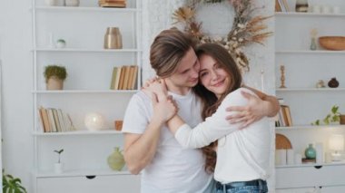 Kafkasyalı çift evli erkek ve kadın ve kız kucaklaşıyorlar. Yeni evde birlikte duruyorlar. Karı koca kucaklaşıyorlar.