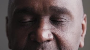 Kameraya bakan üzgün, üzgün siyah erkek gözleri, görme sorunu olan Afrikalı olgun bir adam, göz hekimliği kliniğindeki başarılı lazer düzeltme ameliyatından sonra iyi görüşün tadını çıkarıyor.