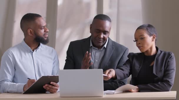 Framgångsrika affärsteam olika åldrar människor kollegor afrikanska specialister afro svarta chefer diskutera projektarbete på konferens möte i office söker bärbara data på nätet skriva analysera ekonomi — Stockvideo