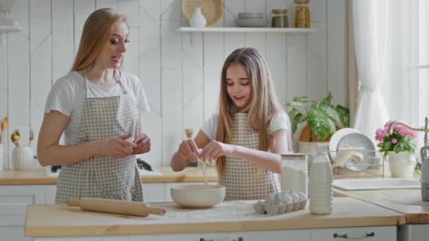 Teenager pige datter barn og munter mor kvinde babysitter stuepige familie bryde æg i skål plade forberede kok dej omelet sammen i køkkenet, baby barn hjælper mor med madlavning, nem læring – Stock-video