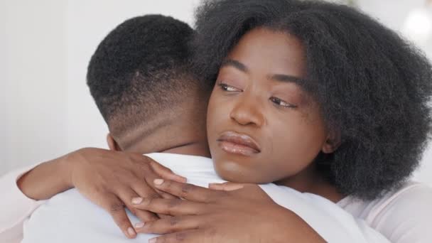 Vista de perto rosto feminino preto de mulher africana triste abraça afro homem irreconhecível. Reconciliação após briga familiar arrependimento pedir desculpas. Esposa abraçando consolador marido reconfortante mostrando empatia — Vídeo de Stock