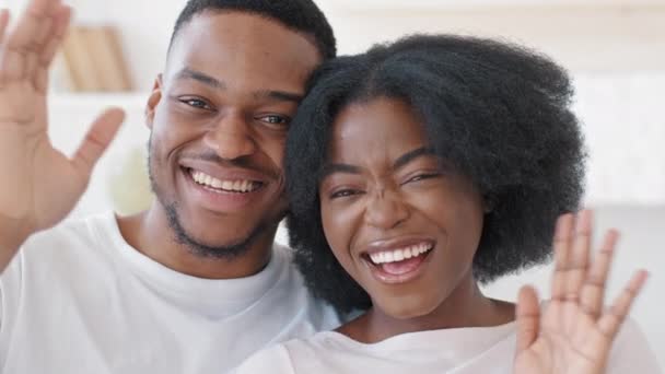 Feliz casal africano família casado afro homem e preto encaracolado mulher abraçando abraço olhando para câmera acenando Olá em casa, marido étnico e esposa satisfeitos clientes sorrir toothy após o serviço odontológico — Vídeo de Stock