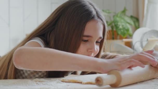 Retrato animado adolescente menina criança filha caucasiano usando rolo pin tentando preparar massa para pastelaria caseira na cozinha em casa. Close-up feliz cara estudante gostando de cozinhar cozimento aprendizagem — Vídeo de Stock