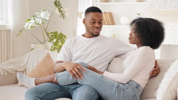 Africano casal casado afro homem e preto étnico mulher namorado e namorada jovem família sentado juntos no sofá-cama em casa descansando no fim de semana conversando conversa discutir notícias comunicando — Vídeo de Stock