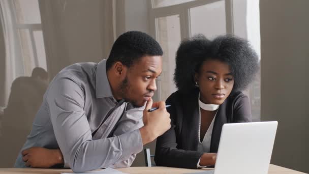 Afroamericano satisfecho mujer y hombre trabajando juntos en el cargo. Mire la pantalla del ordenador portátil, recibió una buena carta de noticias, informe de los empleados, excelente rendimiento financiero. Sorprendidos resultados exitosos — Vídeo de stock