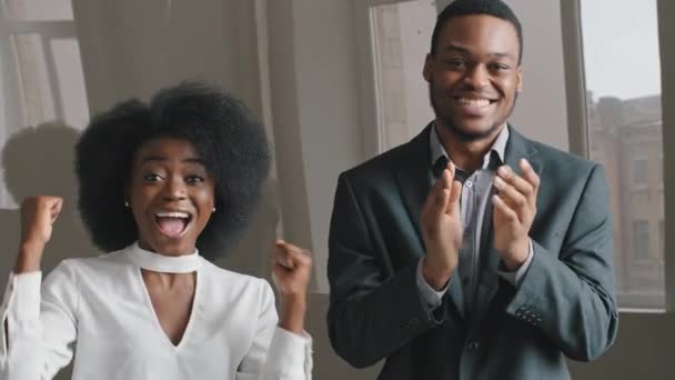 Excited ethnic African American office workers rejoicing win shouting yes, man woman waving clapping hands. Employees received offer contract, business partners satisfied work result celebrate success — Stock Video