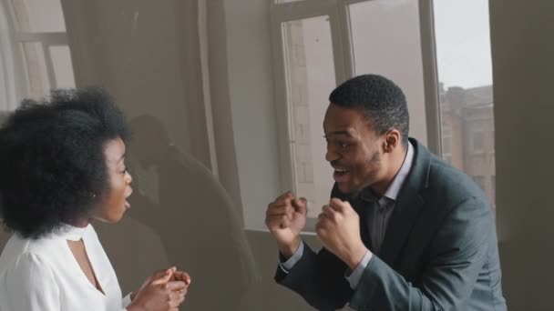 Feliz emocionado Jóvenes trabajadores de oficina afroamericanos reciben oferta comercial especial, noticias fantásticas, oportunidad. Emociones sinceras pareja celebrar el éxito en los negocios o logros personales. — Vídeos de Stock