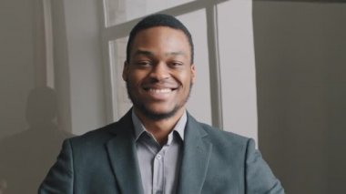 Kafasından vurulan mutlu, kendinden emin, Afro-Amerikalı genç bir adam, iyi bir iş öneriyor. En kaliteli kurumsal hizmetler. Gülümseyen erkek istemci olumlu geri bildirim veriyor