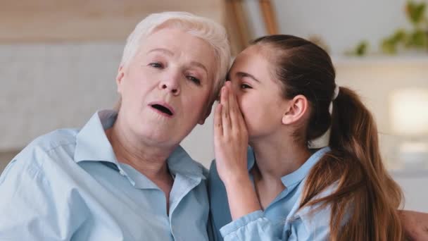 Close up view amorevole vecchia nonna ascolto carino nipotina sussurra segreto nel suo orecchio, Onestà, relazioni affidabili e comprensione tra nonna e nipote concetto di fiducia — Video Stock