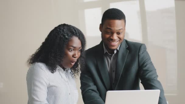 Opgewonden jonge multi-etnische Afro-Amerikaanse collega 's in formele kleding blij kijkend naar laptop scherm, zich verbaasd voelen door het krijgen van e-mail met goed nieuws, vieren het ontvangen van droombaan aanbod — Stockvideo