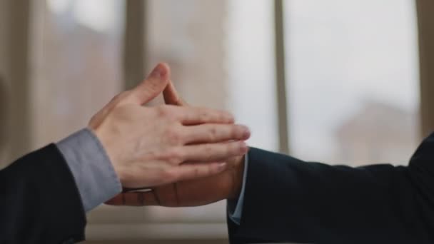 Close-up funny male greeting gesture of partnership, two man African and Caucasian business colleagues clap palms bumping fists waving fingers unusually shaking hands in office near window background — Stock Video