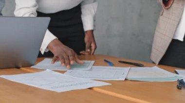 Kadın, Afrikalı ve Kafkasyalı genç iş adamlarını kapatın. Kadın, çeşitli iş arkadaşlarıyla ofiste buluşuyor. Tanımlanamayan iki iş kadını evrak işleriyle uğraşırken beyin fırtınası yapıyor.