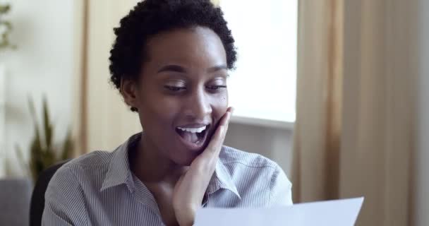 非洲裔美国女性获奖者收到快乐信。女孩检查书信得到了梦想的工作，庆祝胜利。女士很高兴在总公司收到纸质邮件中的好消息 — 图库视频影像