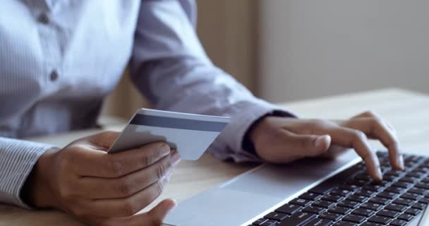 Primer plano de las manos femeninas del titular de la tarjeta de crédito con tarjeta bancaria haciendo el pago. Mujer consumidor que paga por la compra en línea en la tienda web utilizando la tecnología portátil. Sitio web de comercio electrónico pagos concepto de ventas — Vídeos de Stock