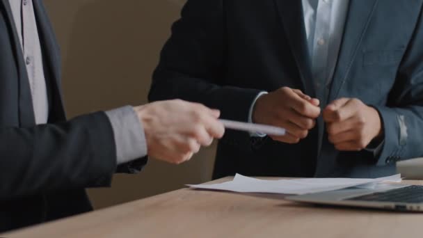 Close-up male hands two unrecognizable multiracial business men in formal suits african and caucasian colleagues stand at office meeting table holding pens pretend playing drums on musical instrument — Vídeo de Stock
