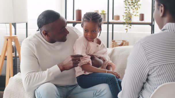 Raadpleging van de psycholoog. Onherkenbare vrouw afro vrouw raadpleegt met afrikaanse volwassen man en tiener kind meisje, adviseert over familieproblemen. Zwarte vader en dochter praten over psychotherapie — Stockvideo