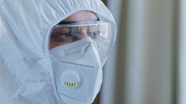 Güvenlik gözlükleri ve koruyucu maske takan kameraya bakan yorgun ve stresli Arap İspanyol doktor erkek yüzü ve gözleri. Laboratuvar çalışanı Coronavirus COVID-19 salgını