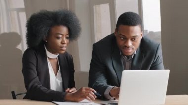 Erkek Afrikalı yönetici akıl hocası, odaklanmış kadın stajyer stajyer, yeni çalışan, iş yerindeki bilgisayar projesini açıklayan, profesyonel yönetici, yeni işçi stajyeri eğiten, yeni beceri öğrenen