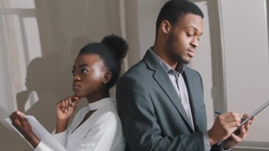 İki ciddi çift ırklı Afrikalı iş arkadaşı, kağıt not defterine notlar yazmak için proje planı üzerinde birlikte çalışıyorlar. İş adamları milenyum boyunca her gün randevu alıyorlar. Ofiste strateji üzerine beyin fırtınası