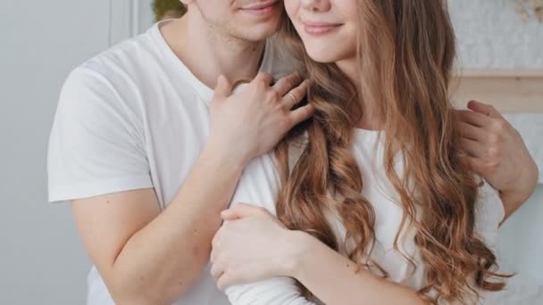 Портрет обрезанный выстрел кавказская супружеская пара супруги молодожены женщина и любящий мужчина тысячелетия обнимая обнимаясь стоя дома наслаждаясь любовью обнимашки парень гладить девушки волосы, нежность концепции — Стоковое видео © jet_po.mail.ru #477089426