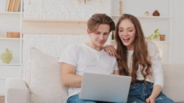 Mutlu Kafkasya milenyum çifti karı ve koca evlerinden kanepeye video görüşmesi yapıyor. Erkek ve kadın internette ailelerle veya arkadaşlarıyla sohbet ediyorlar.