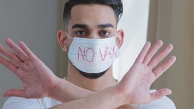 Tıbbi koruyucu maskeli İspanyol bir adamın portresi. Önünde hiçbir aşı kollarını çaprazlamaz. Bu da Covid Coronavirus gribine karşı aşı olmayı reddettiğini gösterir.
