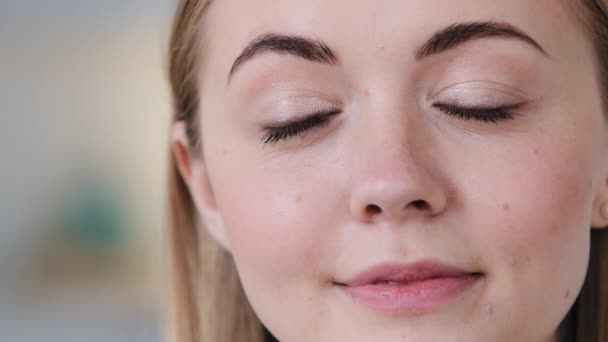 Närbild headshot lugn leende ung dam tusenårig poserar inomhus i rummet, njuter av helgen. Friska flicka känner sinnesfrid, djupt i positiva tankar bekymmersfri hemma ingen stress koncept. — Stockvideo