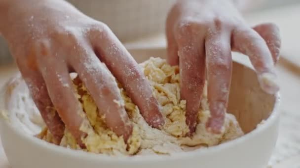 Närbild av kaukasiska childs kvinnliga händer knåda klibbig rå deg med fingrar i skål hemma använda vetemjöl gör bröd hjälper till att laga hemlagad paj. Oigenkännlig flicka i förkläde i kök — Stockvideo