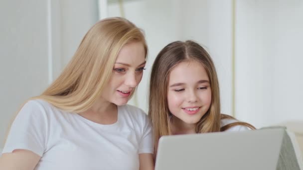 Mulher adulta de meia-idade mãe e filha adolescente estudante sentados juntos em casa olhando para a tela do laptop usando o computador assistindo filme on-line navegar site de notícias de leitura — Vídeo de Stock