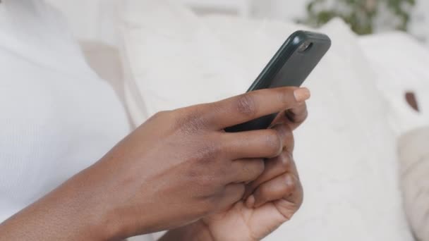 Close-up joven mujer afroamericana sosteniendo el teléfono celular en las manos, el uso de aplicaciones de citas desplazamiento mensajes de texto de la página personal escribir mensaje mantener teléfono inteligente mirar la pantalla navegar por las redes sociales — Vídeo de stock