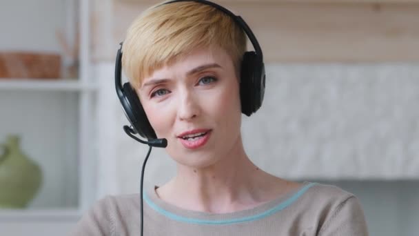 Η Millennial γυναίκα με ακουστικά κοιτάζει την κάμερα να μιλάει μέσω τηλεδιάσκεψης με συναδέλφους. Γυναικεία ακουστικά φορούν συμμετέχουν σε ζωντανή μετάδοση streaming share πω ειδήσεις. Έννοια εκδήλωσης βιντεοκλήσης — Αρχείο Βίντεο