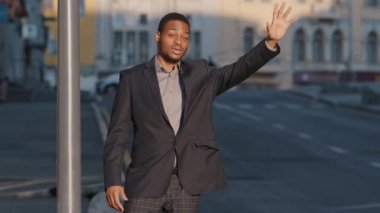 Çekici Afrikalı Amerikalı öğrenci, takım elbiseli genç adam dışarıda taksi bekliyor. Modern iş adamı ya da müdür büyük şehirde araba sürücüsüne işaret veriyor. Taksi servisi kavramı