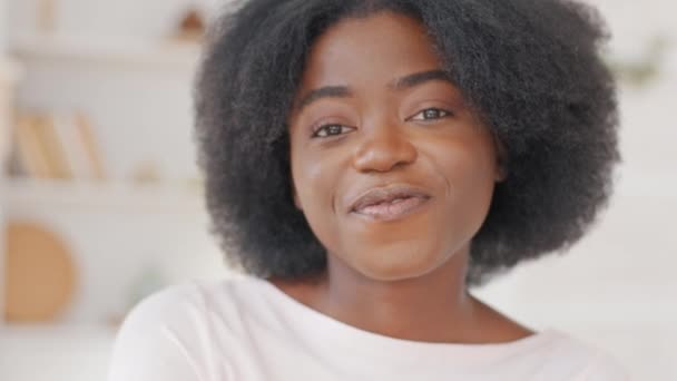 Ritratto di bella giovane ragazza afro-americana con i capelli ricci in stile afro guarda in macchina fotografica danza muove la testa alla musica sorridente flirtare. Primo piano etnico nero millenaria donna in posa mista signora razza — Video Stock