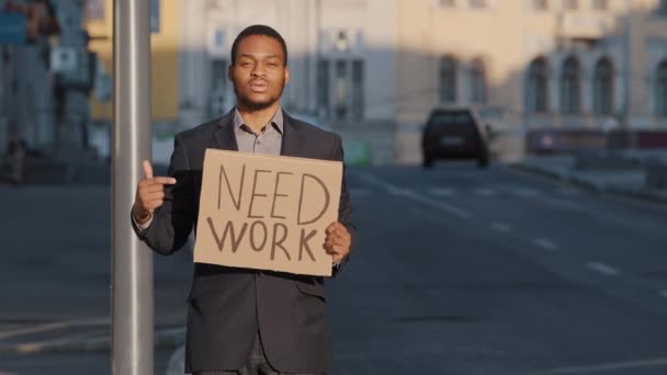 Misto razza uomo d'affari tenendo segno Need Work punti indice dito. Ritratto di Giovane uomo in piedi all'aperto tenere poster. Licenziato operaio bianco millenario in cerca di lavoro durante la crisi pandemica — Video Stock