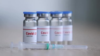 Hastalık için covid-19 aşısı olan dört şişe, salgın ilacı tedavisi ilacı şırınganın yanındaki hastane kliniği eczanesinde duruyor, aşı aşılama konsepti detayları...