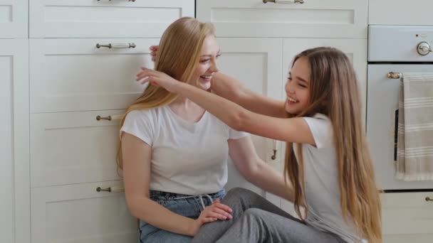Uśmiechnięta kaukaska rodzina dojrzała dorosła matka i nastolatka dziewczynka córka siedzi w domu na podłodze w kuchni przytulanie przytulanie obejmując się przytulić uścisk komunikacja więź pokazując miłość — Wideo stockowe