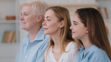 Profile faces in row three generation of women 60s middle-aged senior grandmother, grown up daughter young mommy and little granddaughter. Multi-generational happy female family portraits concept