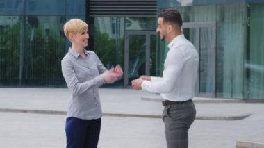 Çok ırklı iş arkadaşları Arap İspanyol menajer patron ve açık havada dikilen beyaz sarışın kadın hareketli el hareketleri yapıyorlar. Parmaklarını vuruyormuş gibi yapıyorsun.