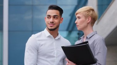 Çok ırklı iş arkadaşları. İki mimar, İspanyol adam ve beyaz kadın. Dosyayla el ele tutuşup açık havada yeni projeyi tartışıyorlar. Kadın danışman, erkek yatırımcıya danıştı