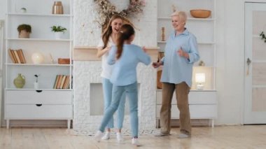 Active multigenerational female family having fun. Old grandma, young adult mom daughter and granddaughter play at home. 3 three age multi generation women family dancing together in living room