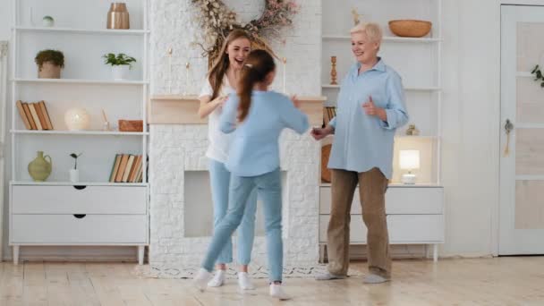 Aktive Mehrgenerationenfamilie mit Spaß. Alte Oma, junge erwachsene Mutter, Tochter und Enkelin spielen zu Hause. 3 Drei-Generationen-Mehrgenerationenfamilie tanzt gemeinsam im Wohnzimmer — Stockvideo